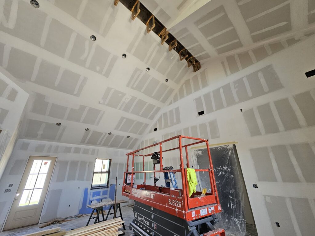 Industrial drywall installation using a scissor lift with tall ceilings in Waco Tx